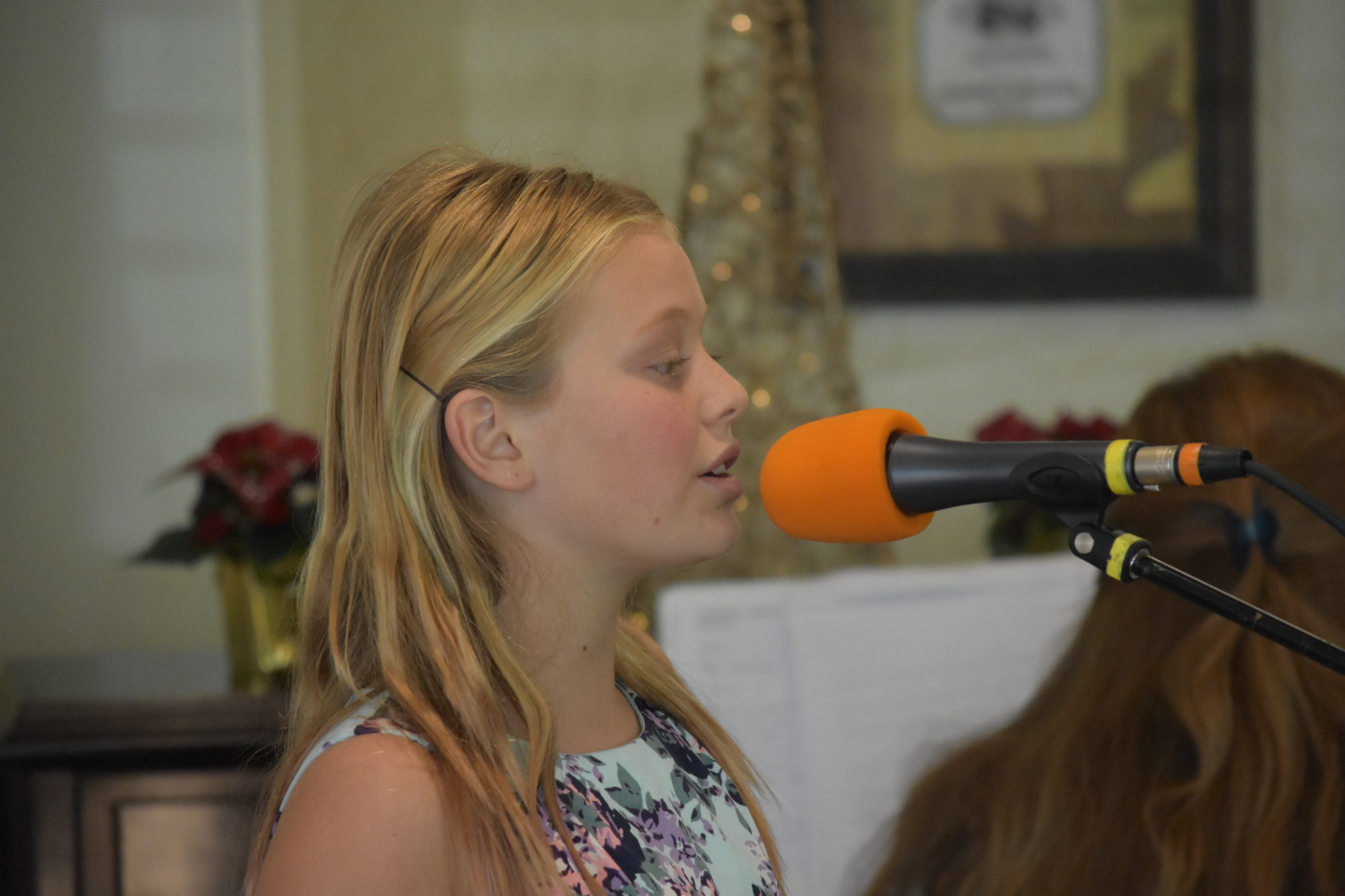 A student concentrating on a song at a microphone.