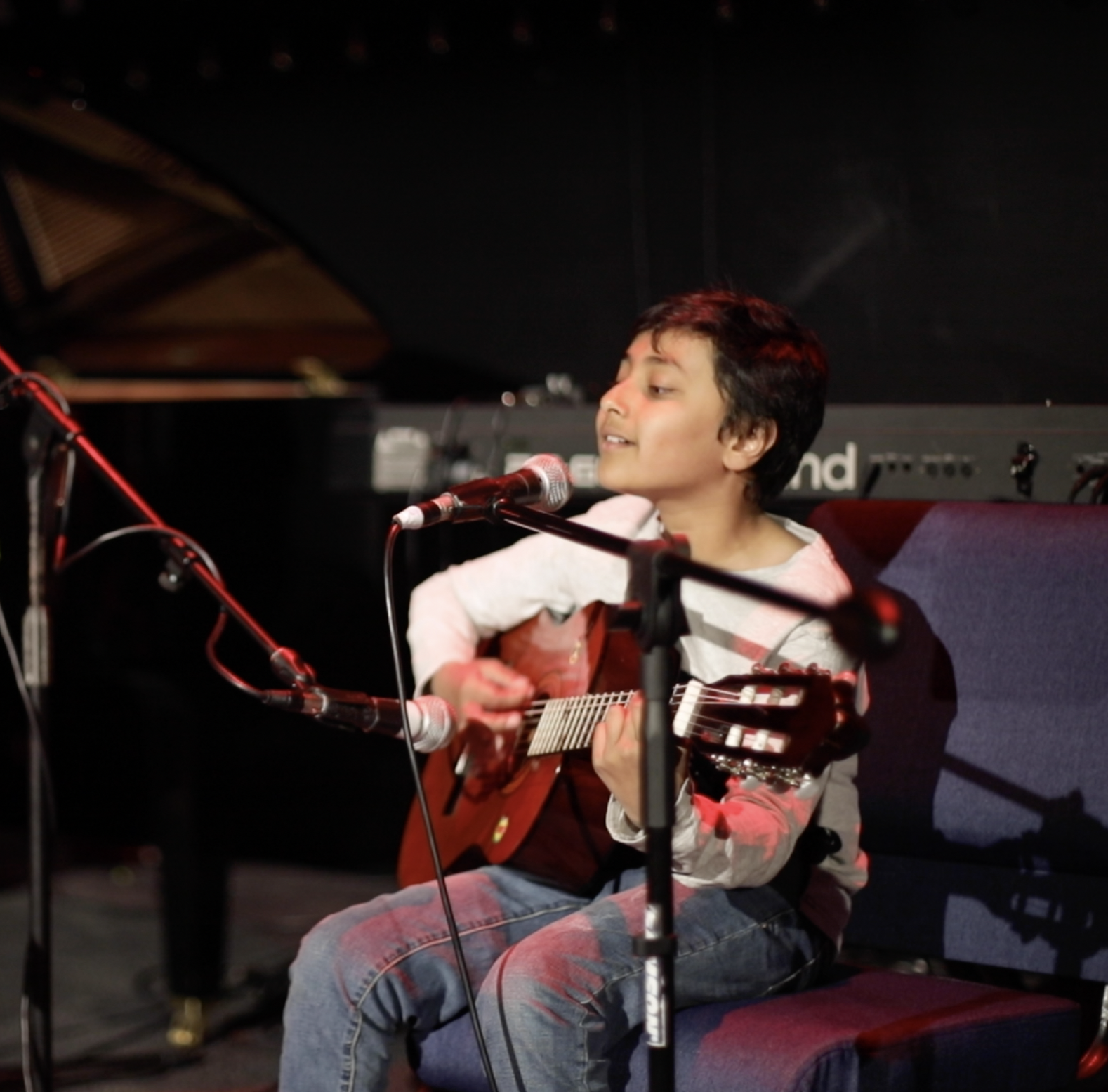 A young musician playing guitar and singing