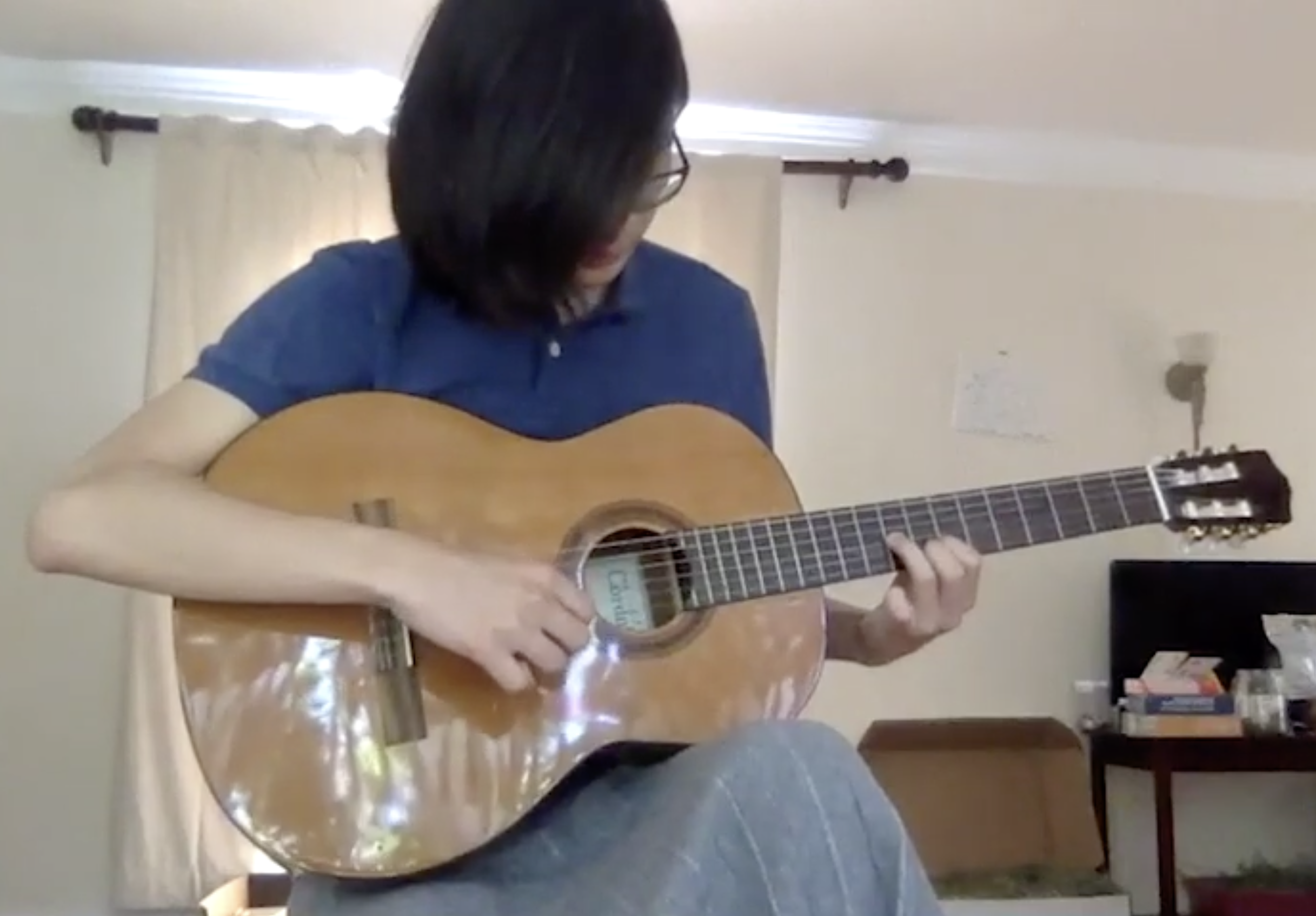 A student finding notes on a classical guitar.