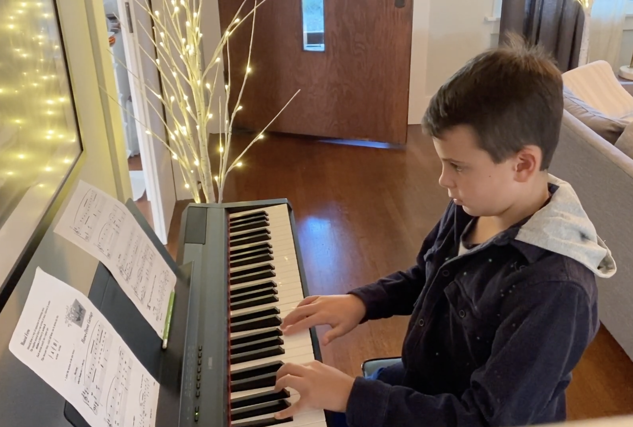 A student playing a keyboard at home.